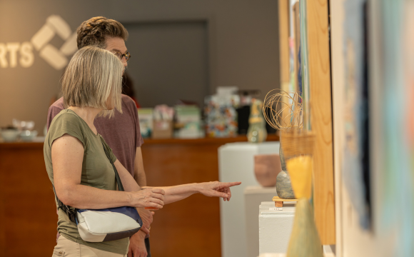 A couple admiring artwork at Quad City Arts