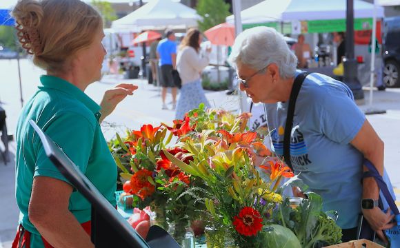 Lady smelling flowers at the Rock Island Farmers Market