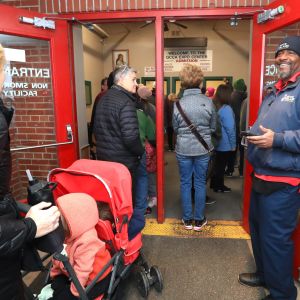 Man greeting people at the door during event