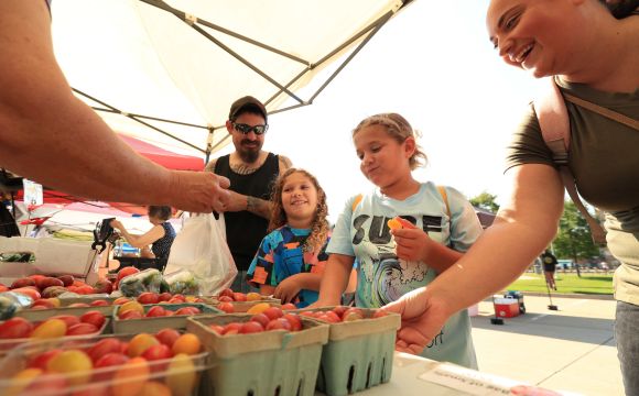 Lady selecting produce at the downtown Rock Islands Farmers Market