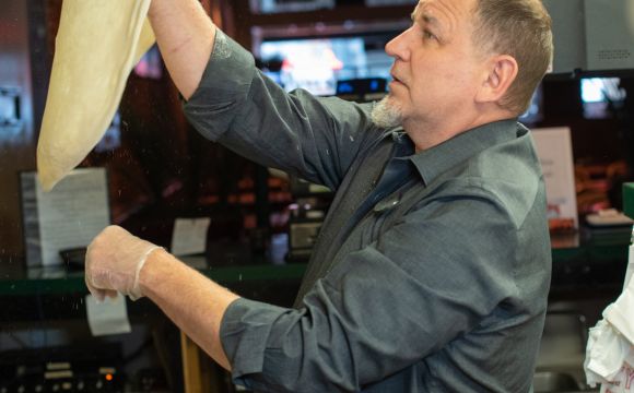 a man tossing pizza at Huckelberry's