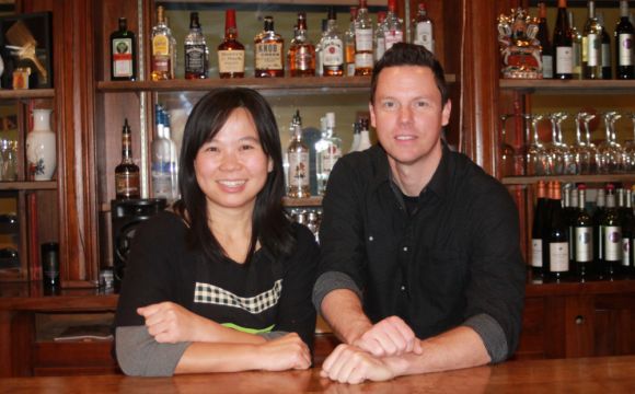 The owners of Soi 2 Thai Street posing for a photo behind a bar