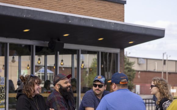 people on a bar patio at Wake Brewing