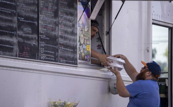 a man receiving his order at a food truck at Wake Brewing