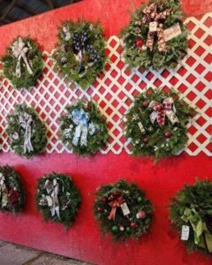 Holiday-themed wreaths on a wall.